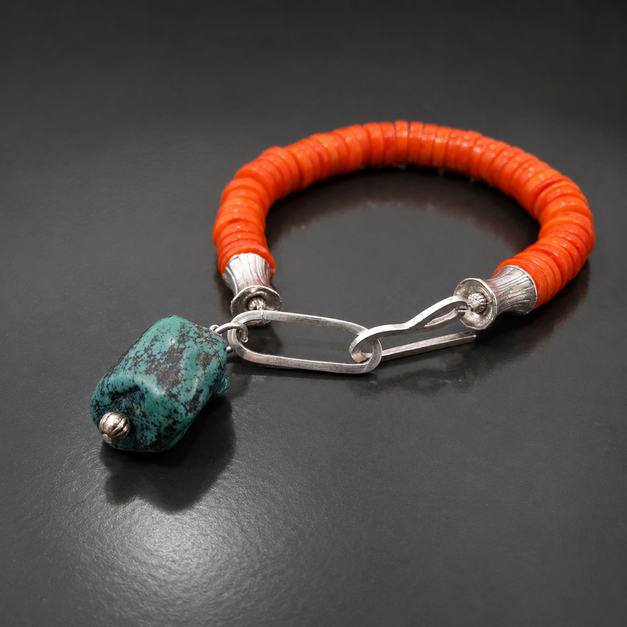 Bracelet with coral discs silver finials and turquoise charm.