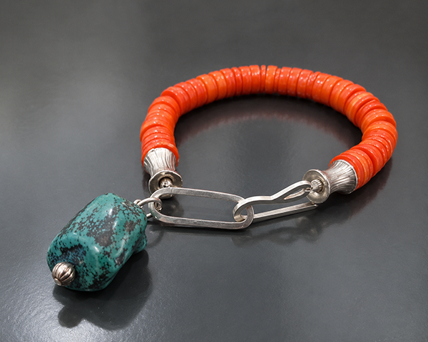 Bracelet with coral discs silver finials and turquoise charm.