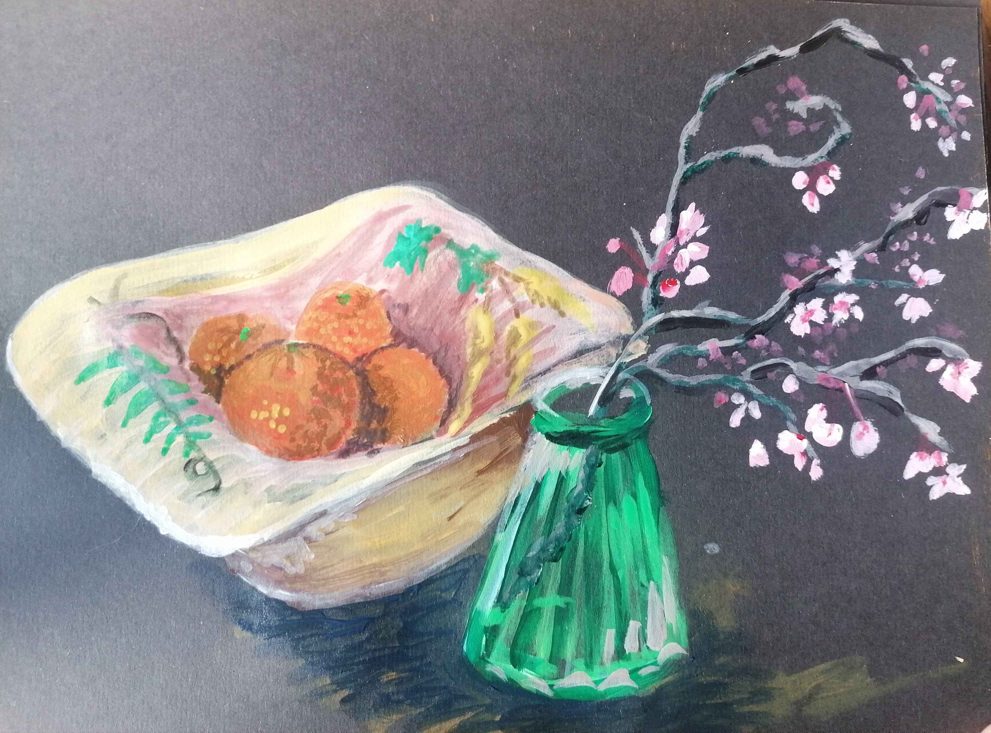 Blossom and oranges in jug on black