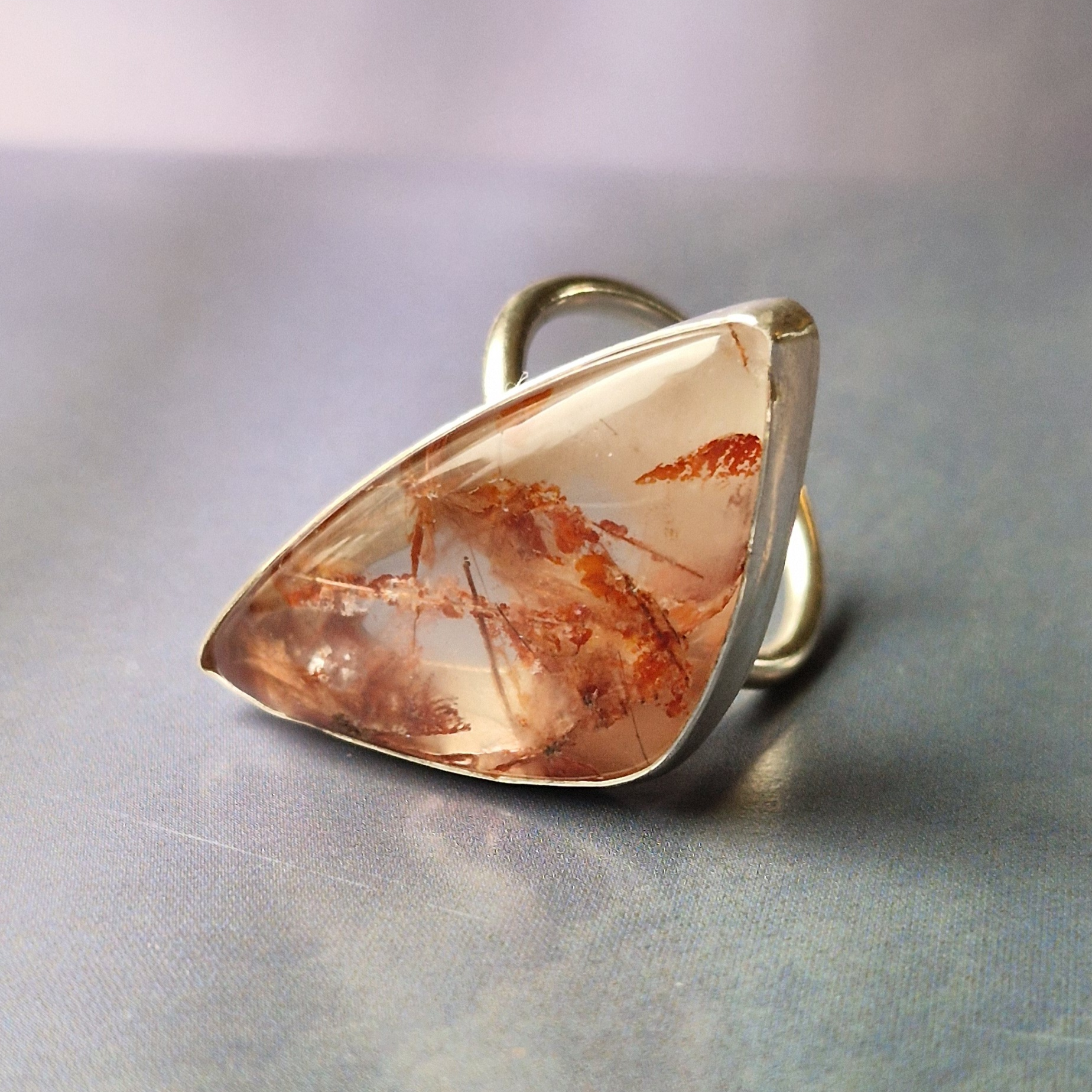 A silver ring with irregular copper rutile stone