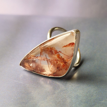 A silver ring with irregular copper rutile stone