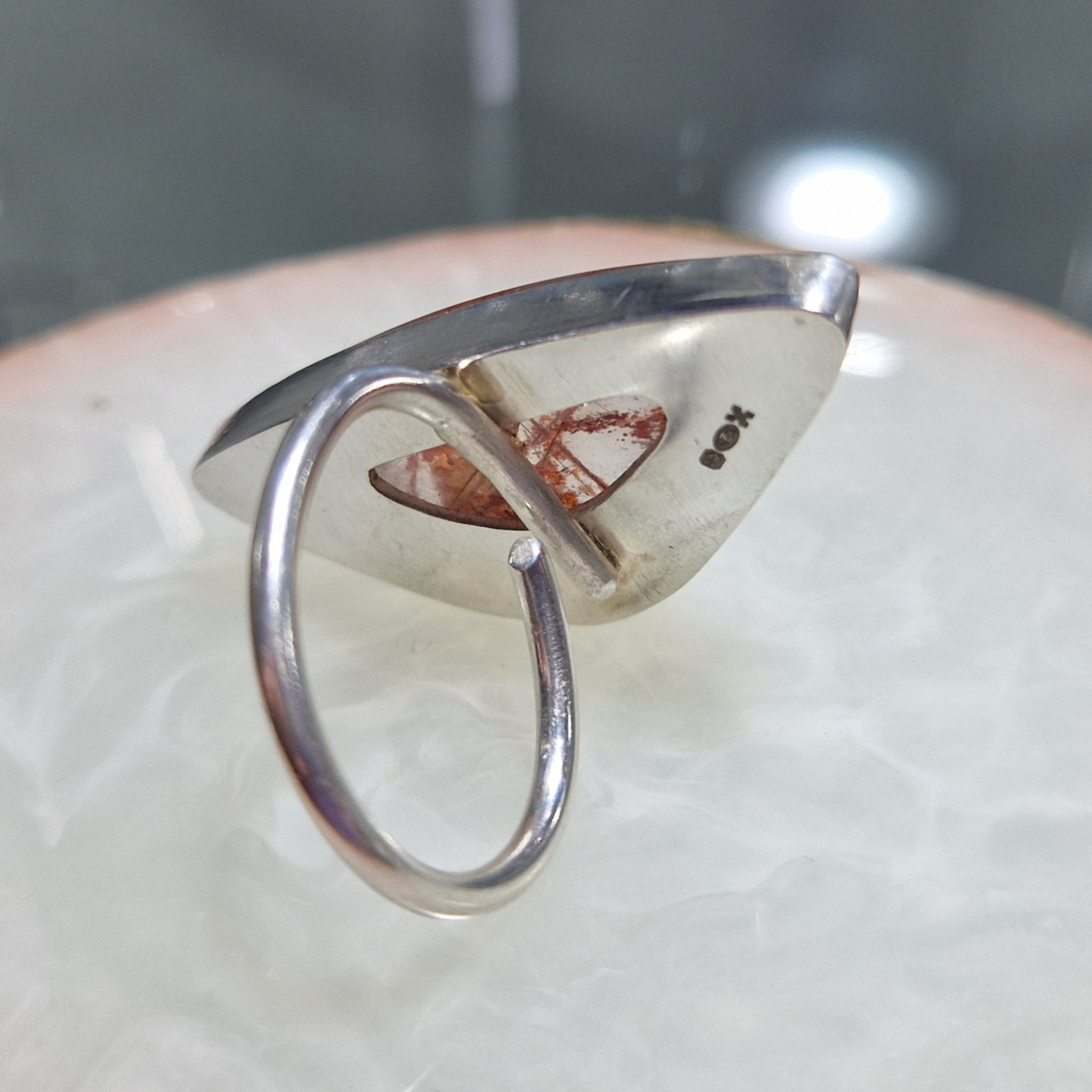 A silver ring with irregular copper rutile stone