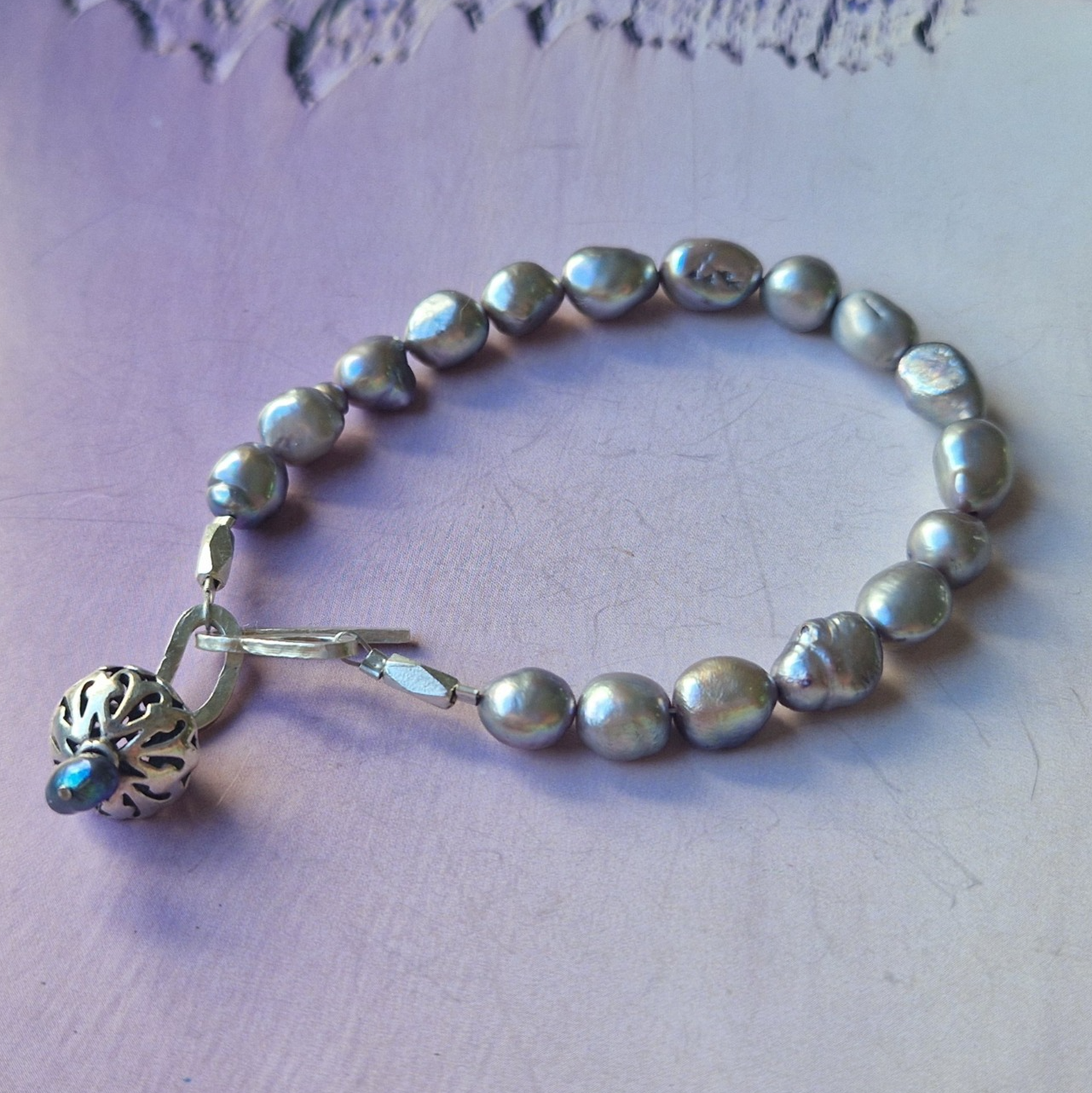 Grey lustre pearl bracelet with silver charm and clasp